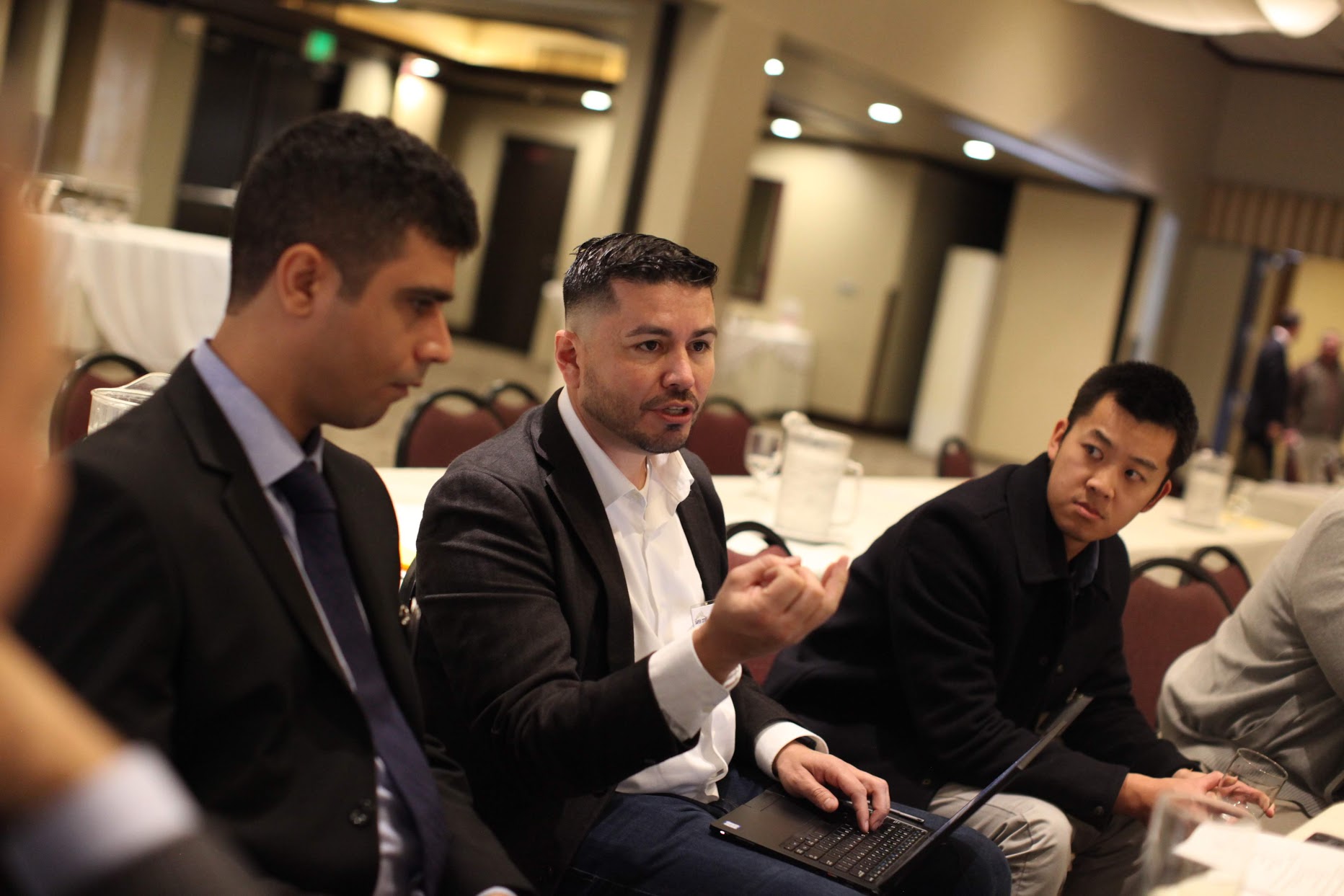 a group of men sitting at a table talking