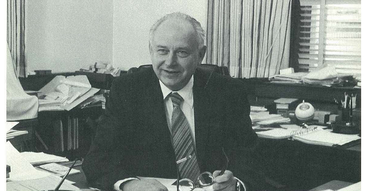 a man in a suit sitting at a desk
